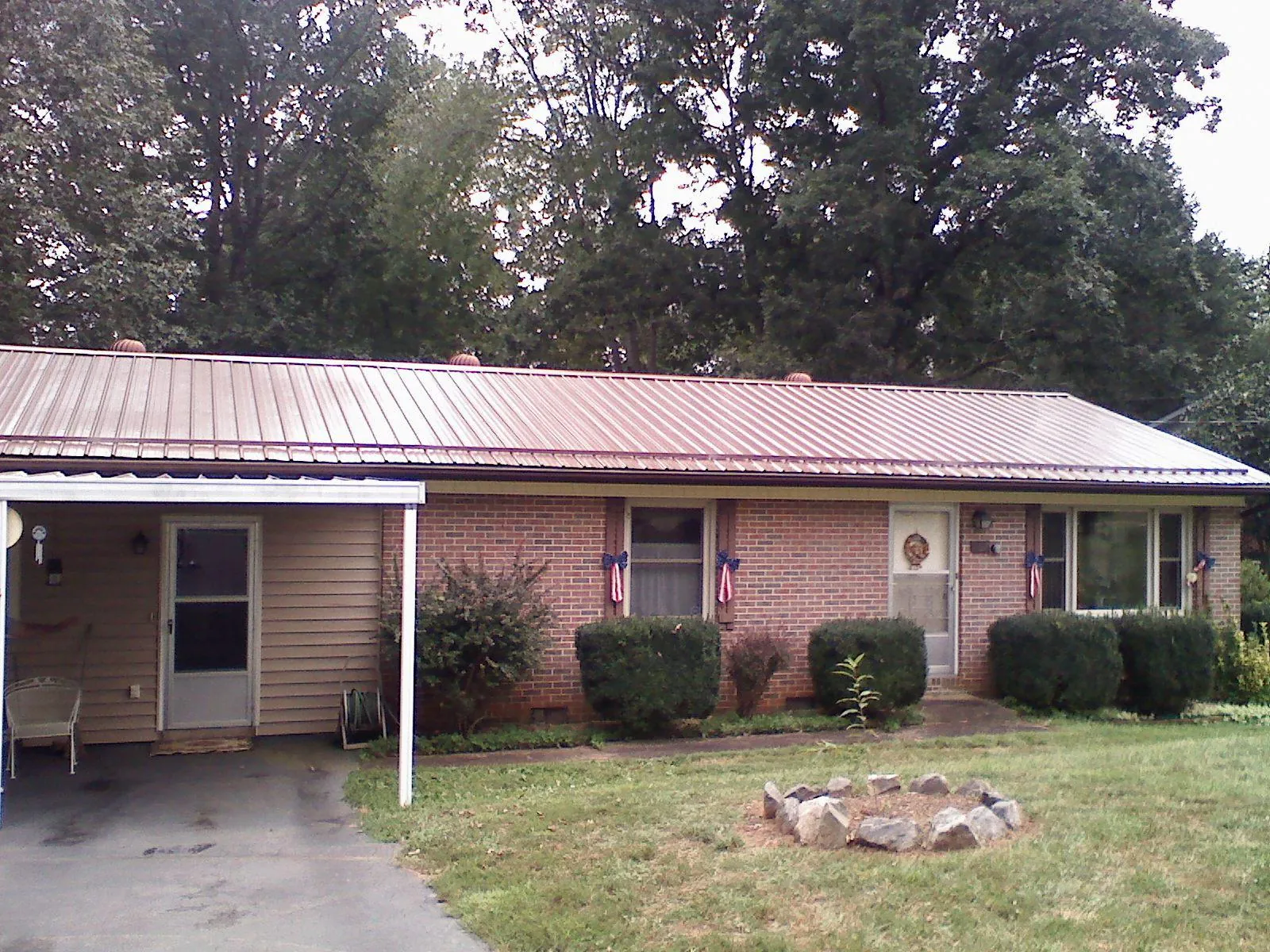 Bronze metal roof and carport on a brick ranch home — Roof Repair work by our crew in Colonia
